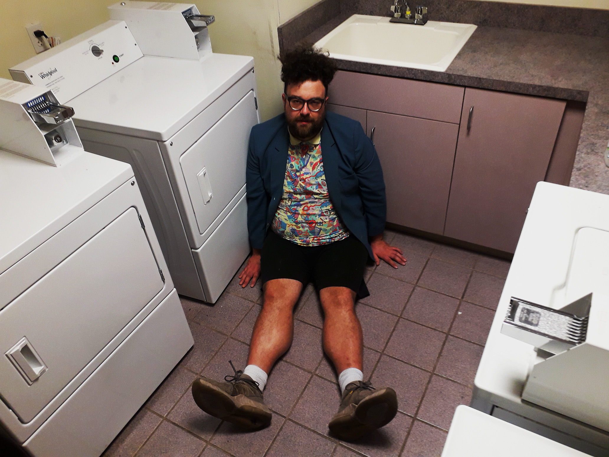 The musical artist sitting on the floor of a motel laundry